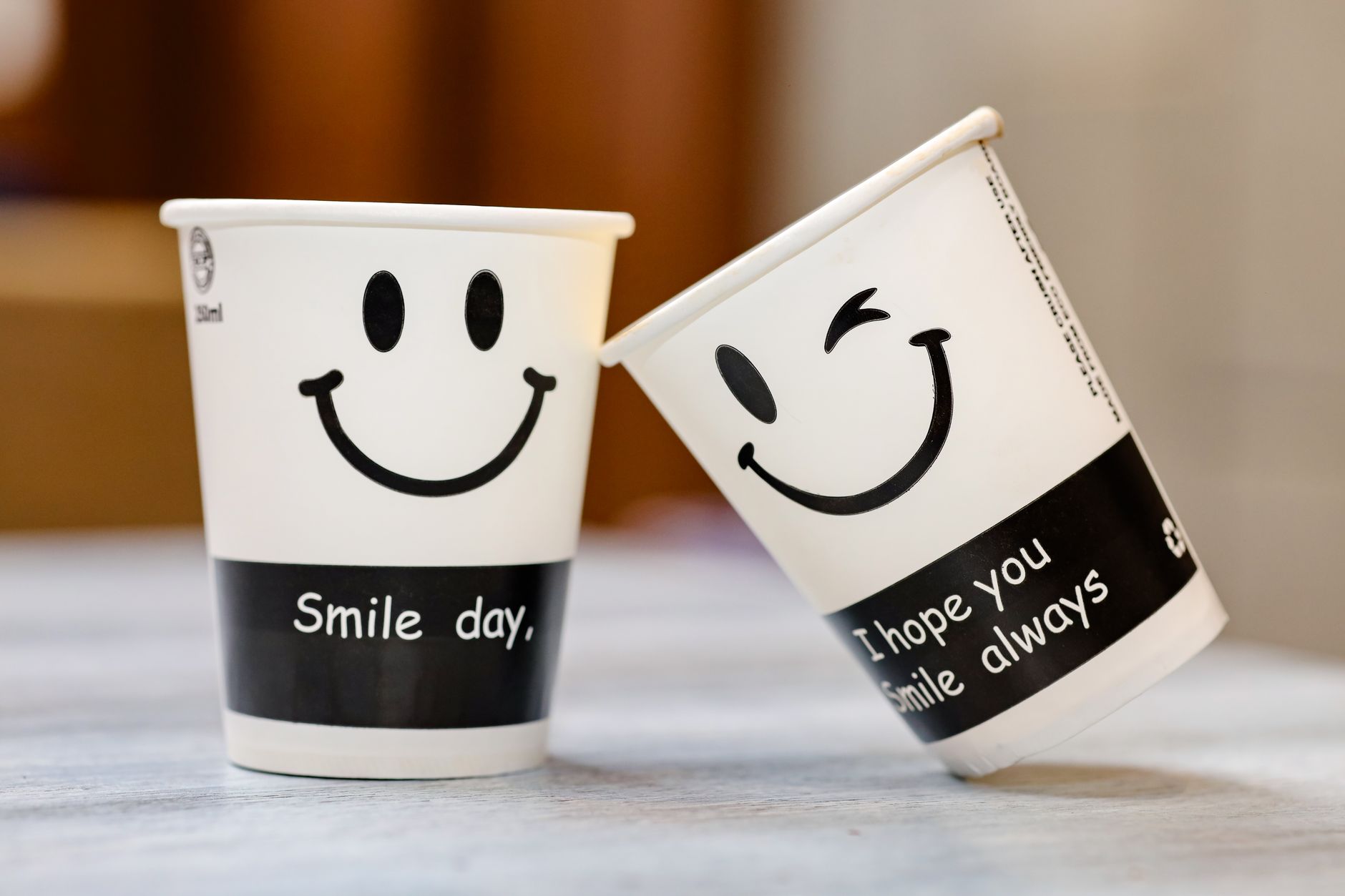 smiling paper cups with inspirational text